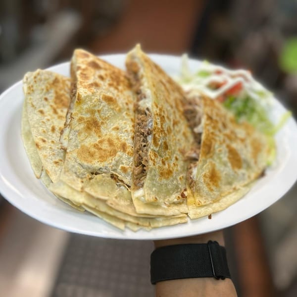 MLT's quesadillas, filled with meat and cheese, served with a side of lettuce and tomato.